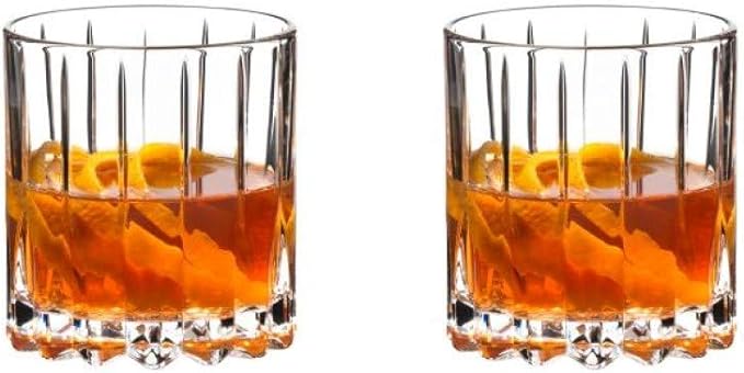 Two Riedel neat glasses with a drink, possibly a whiskey-based cocktail, visible at the bottom.