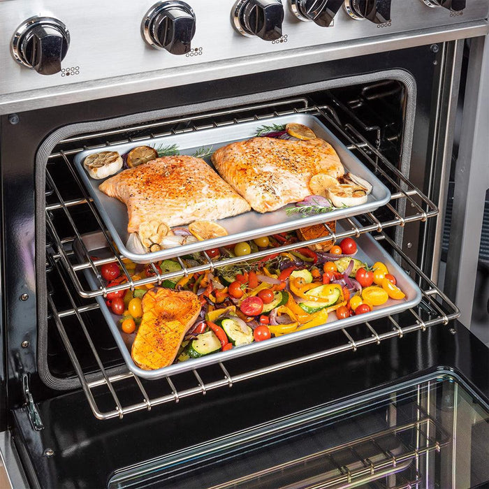 Viking Culinary 2 Piece Nonstick Baking Sheet Set, Silver, 15" & 18" with cooked salmon and sliced vegetables on both sheets in an oven