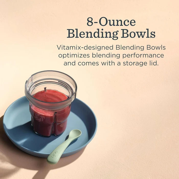 Vitamix-designed 8-ounce blending bowl with a clear plastic container holding red liquid, shown on a blue saucer with a mint green spoon against a warm beige background with product text.