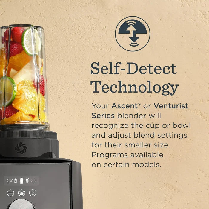 A countertop blender with a clear cup filled with fruit and juice, shown beside text on a beige wall reading 'Self-Detect Technology' and describing the blender's adaptive blending settings.