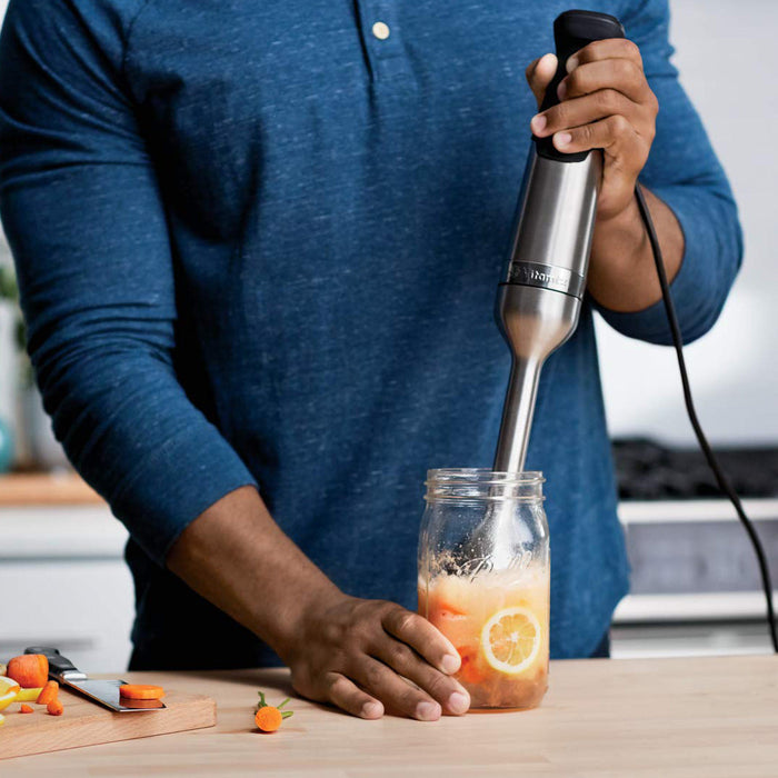 Someone using Vitamix immersion blender in a mason jar