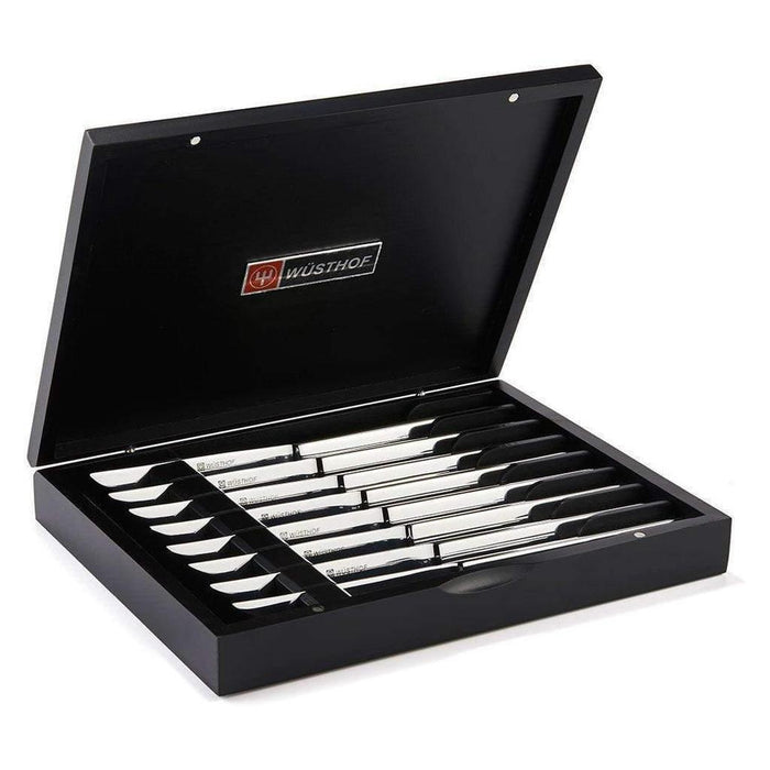 8 piece stainless steak knife set in black wooden chest displayed inside the chest on a white background