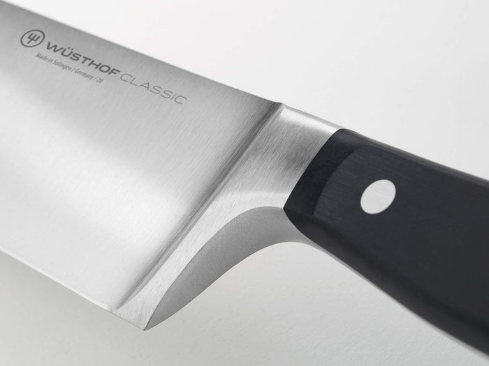Close-up of the hilt of the Wüsthof Classic knife on a light gray background