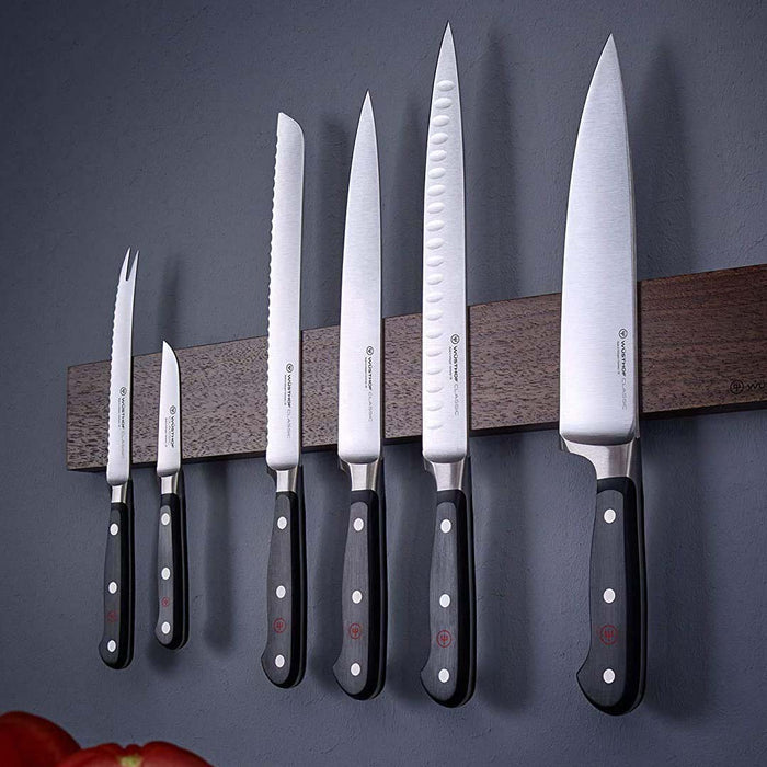 Set of 6 Wusthof knives hanging from a magnetic wooden knife block on a wall