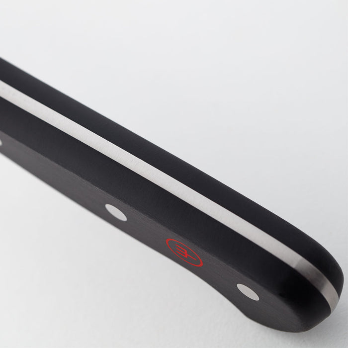 Close up of handle of Wusthof classic hollow edge nakiri knife displayed on a white background