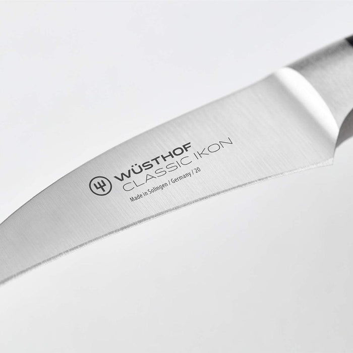Close up of blade of Wusthof Classic Ikon Curved Peeling Knife (2.75") displayed on a white background