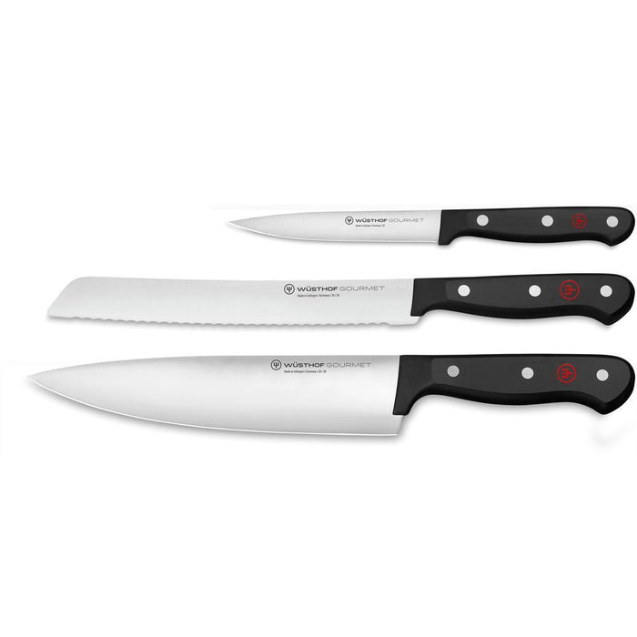 A set of three Wusthof Gourmet knives with stainless steel blades and black polyester handles, including a utility knife, bread knife, and cook's knife.