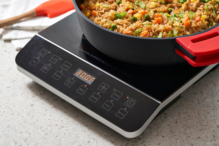 Zavor onyx induction cooktop with fried rice within a pot and digital screen with buttons on a countertop